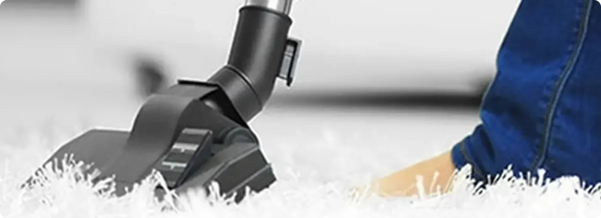 Close-up of a professional vacuuming a white carpet in Davis.